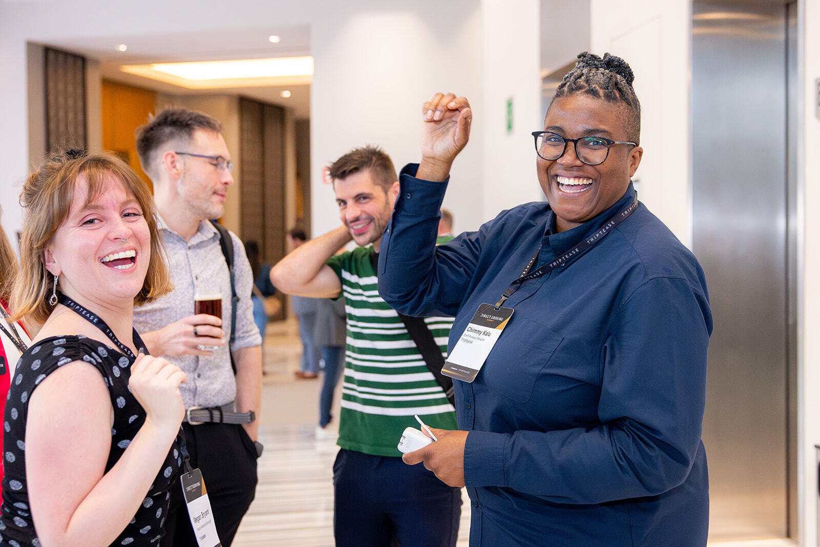 Colleagues laughing and celebrating together in the hallway at the Direct Booking Summit